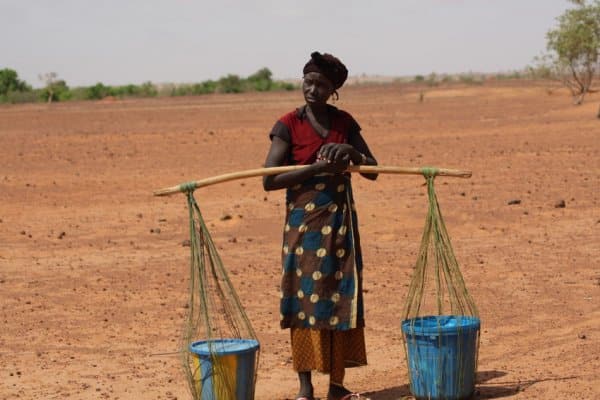 A local woman with a water carrying contraption waits patiently. Niger