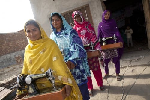 Women in Pakistan hold sewing machines, part of Islamic Relief's livelihoods programme, helping us improve social justice.